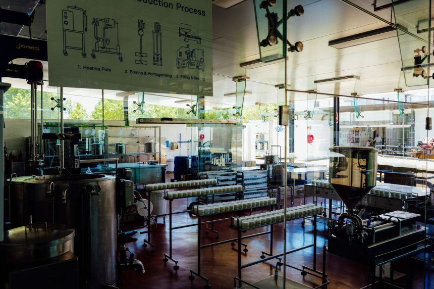 Interior de uma moderna unidade de processamento de alimentos, com máquinas industriais e uma linha de produção.