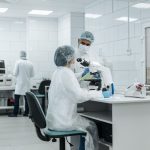 Cientistas trabalham com microscópios em um laboratório equipado para pesquisa.