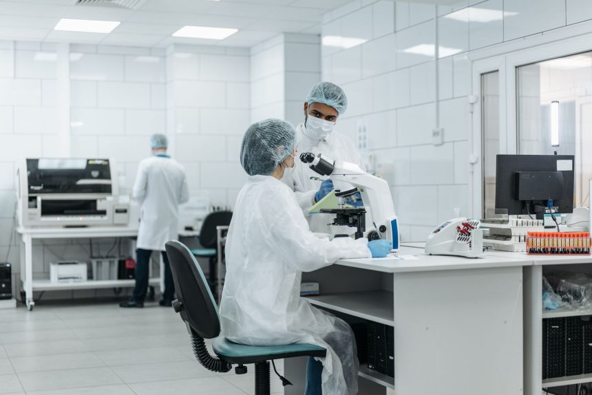 Cientistas trabalham com microscópios em um laboratório equipado para pesquisa.